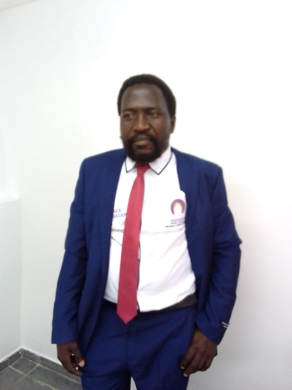 A Mshishi area manager in a blue corporate suit and red tie.